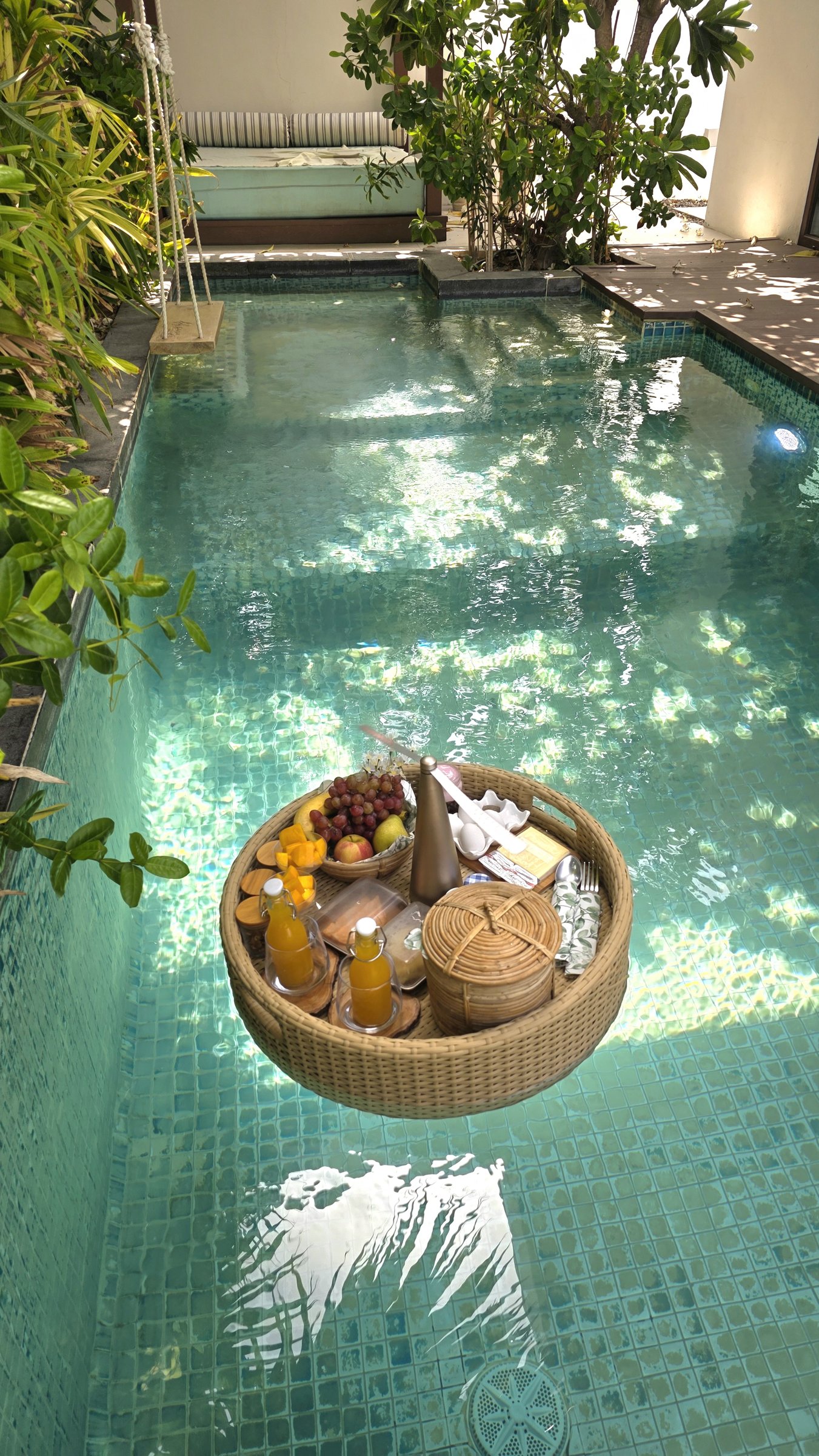 Breakfast on a floating tray in the sunlit pool